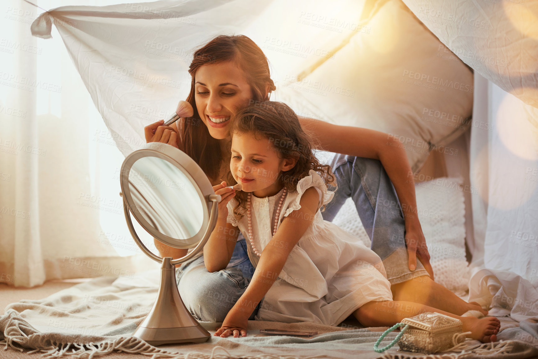 Buy stock photo Shot of a mother and daughter having fun and playing around with makeup