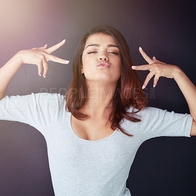 Buy stock photo Studio, kiss lips and woman with peace sign, cool emoji and hand gesture on face for expression. Female person, confident portrait and edgy girl model in Italy with casual fun pout on dark background