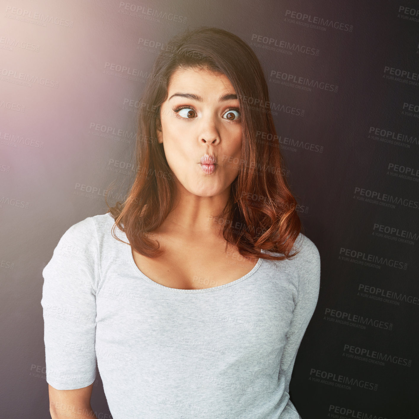 Buy stock photo Cropped shot of a beautiful young woman making a face in the studio