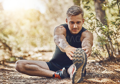 Buy stock photo Man is stretching legs, running in forest and fitness with cardio, workout and training outdoor. Young male athlete, runner with warm up and ready to start run, exercise in nature with sport shoes