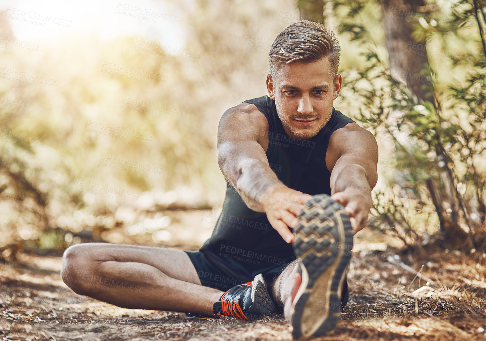 Buy stock photo Man is stretching legs, running in forest and fitness with cardio, workout and training outdoor. Young male athlete, runner with warm up and ready to start run, exercise in nature with sport shoes