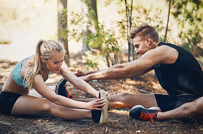 Buy stock photo Shot of a young couple stretching together outdoors