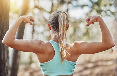 Buy stock photo Shot of a young woman flexing her arms outdoors