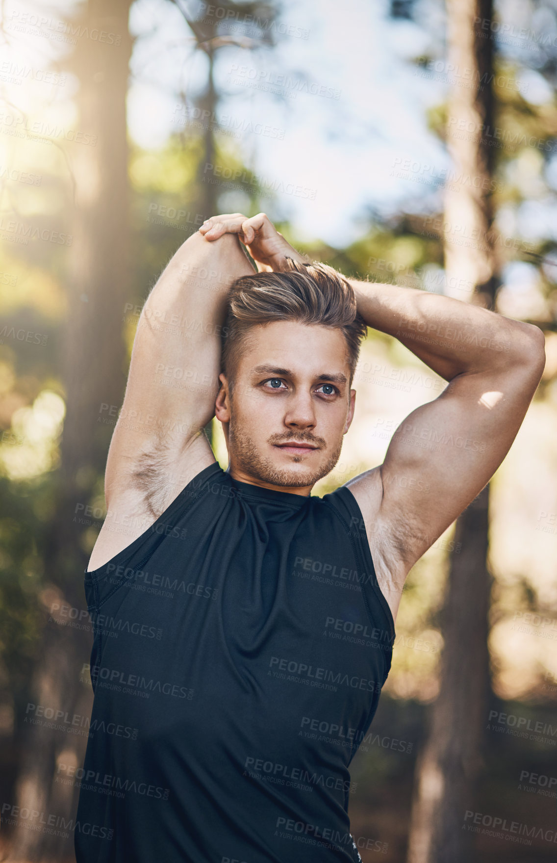 Buy stock photo Shot of a young man stretching outdoors