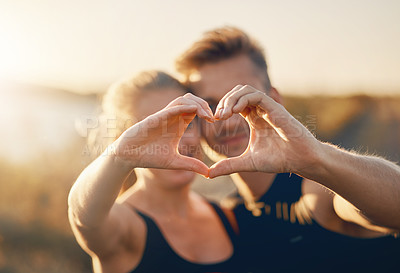 Buy stock photo Shot of a young couple making a heart shape with their hands outdoors