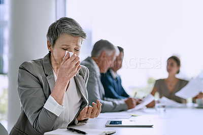 Buy stock photo Cropped shot of a sick businesswoman blowing her nose in the boardroom