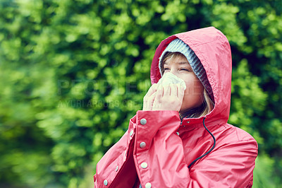 Buy stock photo Cropped shot of a young woman blowing her nose outdoors