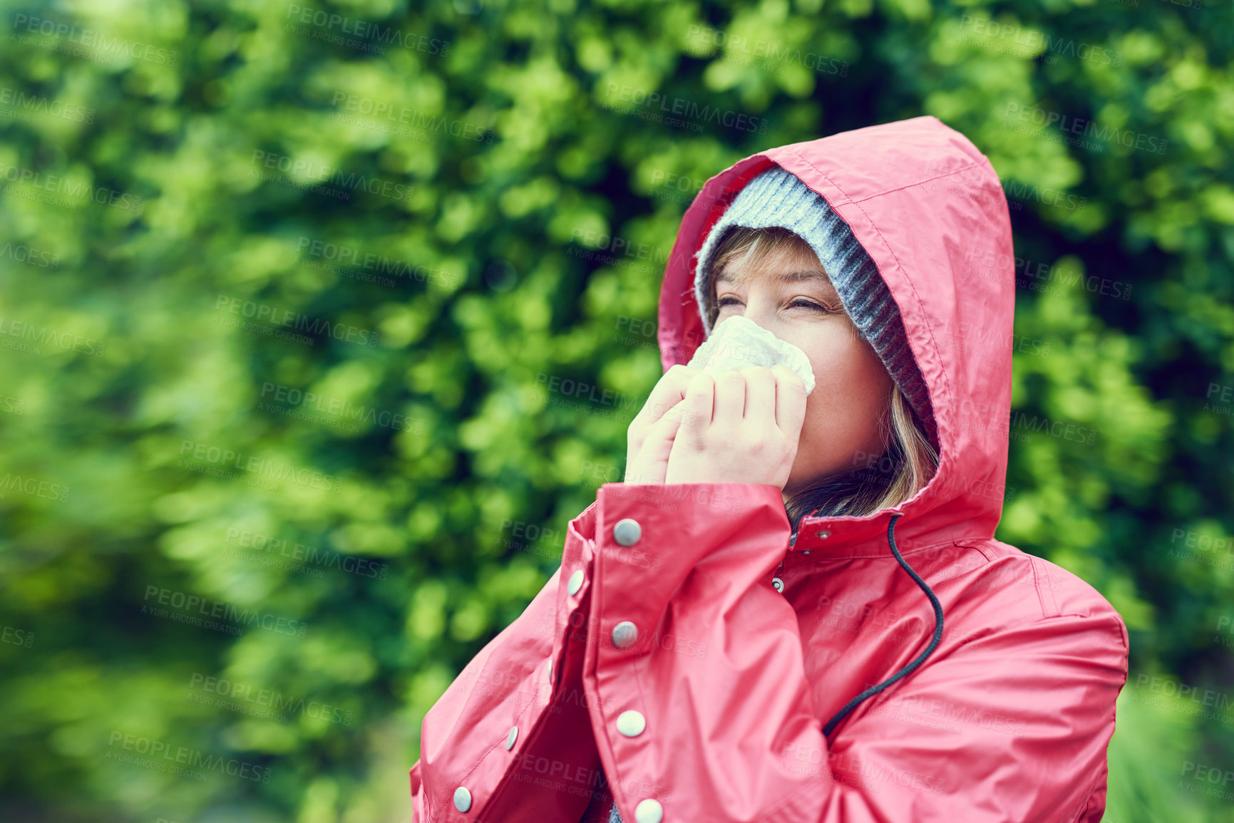 Buy stock photo Cropped shot of a young woman blowing her nose outdoors