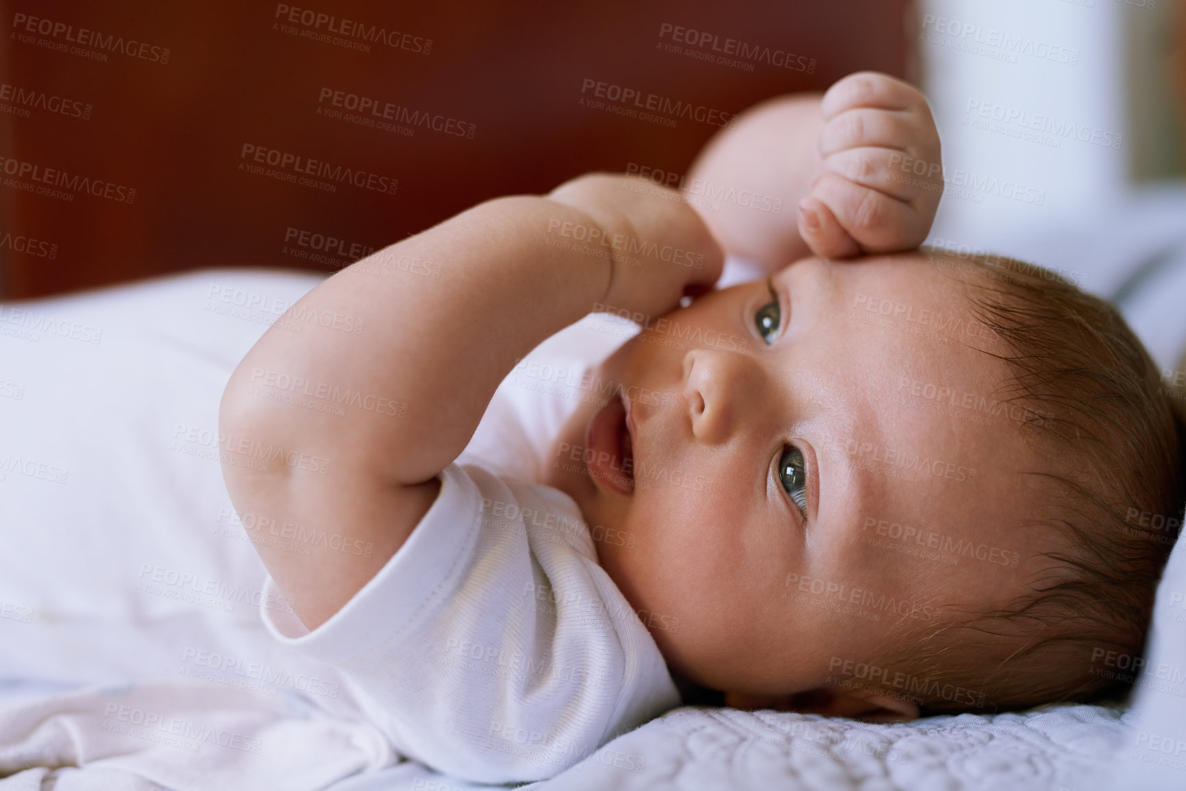 Buy stock photo Shot of an adorable baby boy lying down on a bed at home