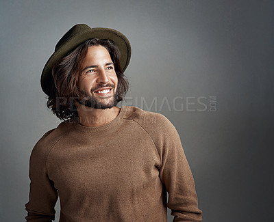 Buy stock photo Studio shot of a happy and handsome young man wearing a hat against a gray background