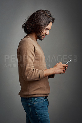 Buy stock photo Profile, man and smartphone in studio for connection, streaming and online or mobile app. Smile, male model and social media or internet for networking, communication and typing by dark background