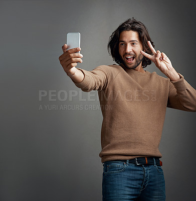 Buy stock photo Selfie, smartphone and man with peace sign in studio for profile picture, social media or memory on dark background. Photography, hand gesture and person for happiness, blog post or communication