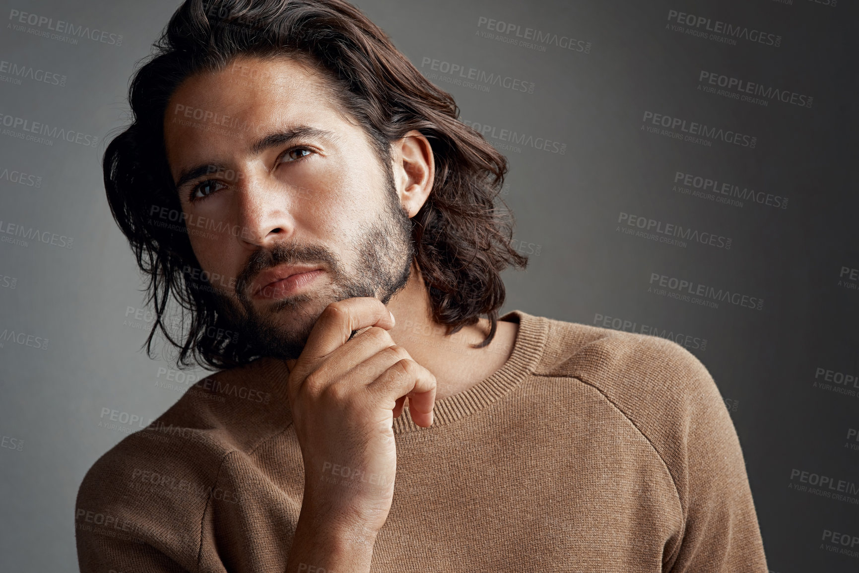 Buy stock photo Studio shot of a handsome young man looking thoughtful against a gray background