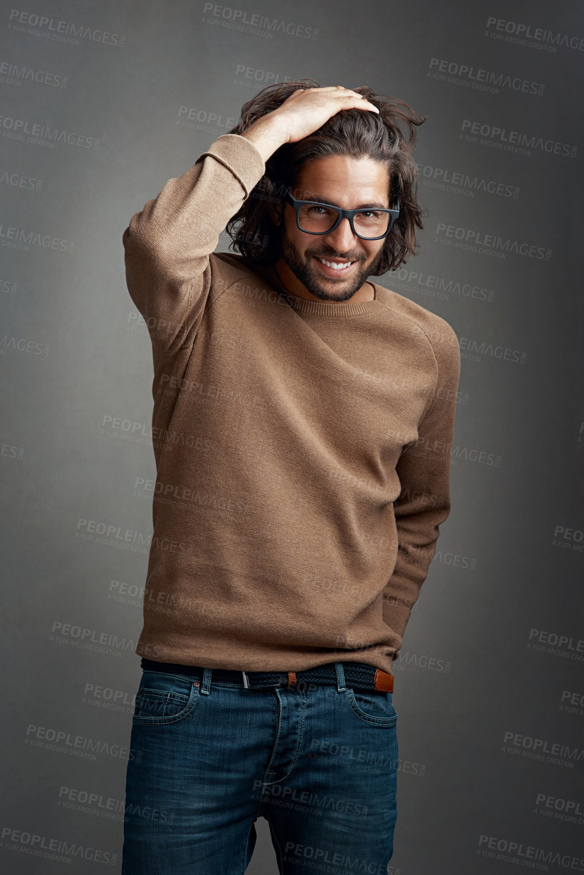 Buy stock photo Fashion, portrait and man in studio with smile for trendy clothes, casual outfit or denim jeans on gray background. Style, wardrobe and male model for designer glasses, winter jersey or confidence