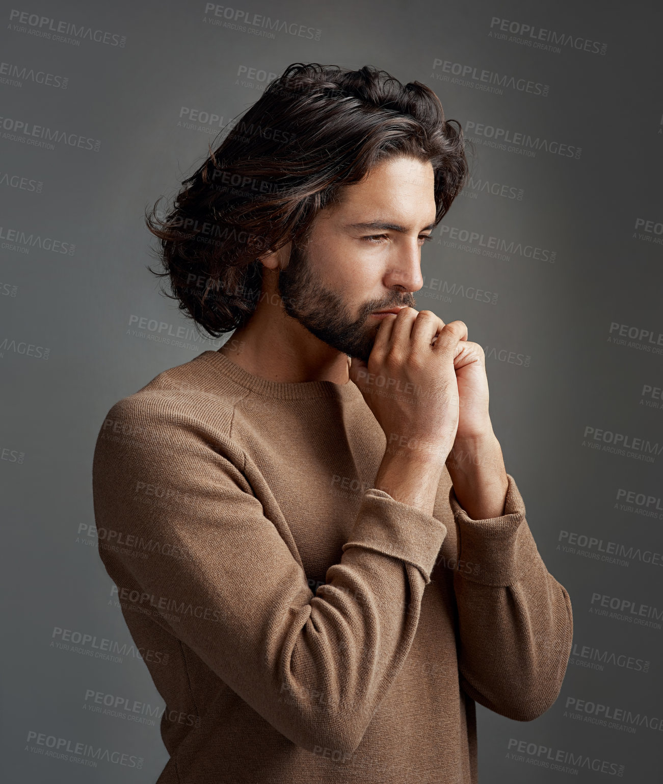 Buy stock photo Studio shot of a handsome young man praying against a gray background