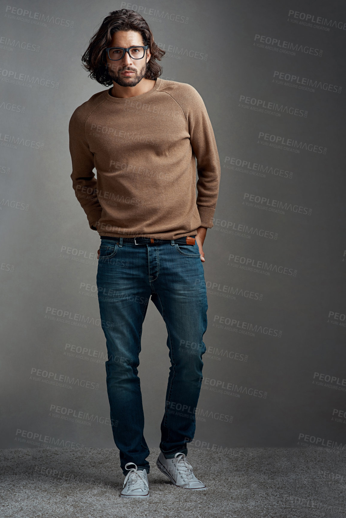 Buy stock photo Studio shot of a handsome young man posing against a gray background