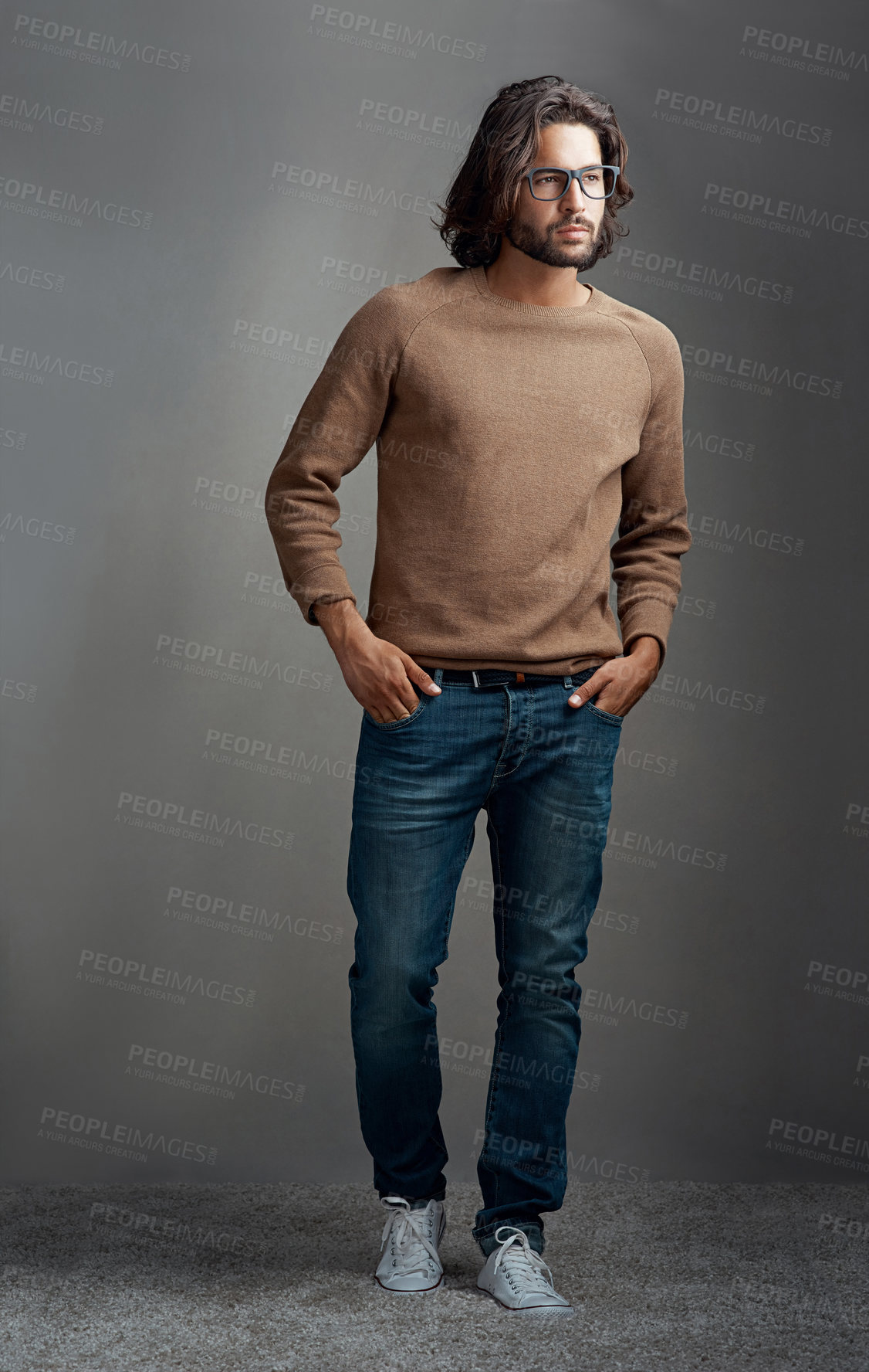 Buy stock photo Man, thinking and fashion portrait in studio with wardrobe ideas for style, comfortable jeans or clothes. Serious, male person and trendy jersey, brand glasses or hands in pocket on grey background