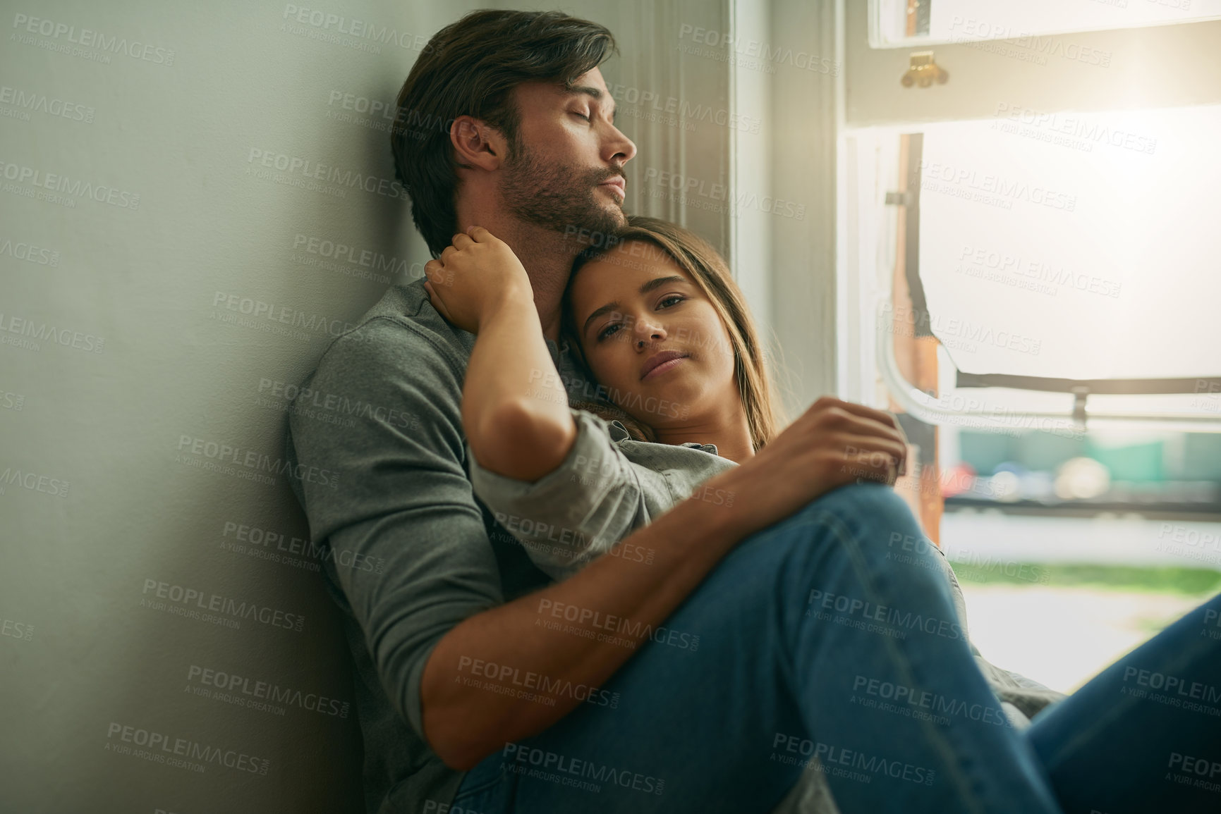 Buy stock photo Shot of an affectionate young couple at home holding each other