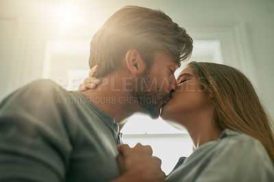 Buy stock photo Shot of an affectionate young couple sharing a kiss