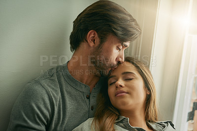Buy stock photo Shot of an affectionate young couple relaxing and holding each other