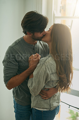 Buy stock photo Shot of an affectionate young couple sharing a kiss
