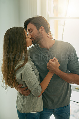 Buy stock photo Shot of an affectionate young couple holding and kissing each other