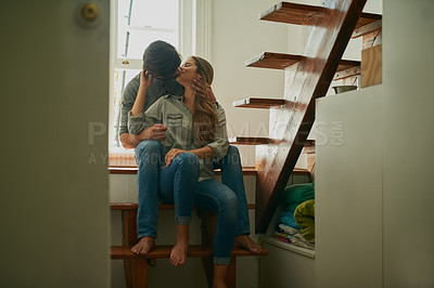 Buy stock photo Shot of an affectionate young couple at home sharing a kiss