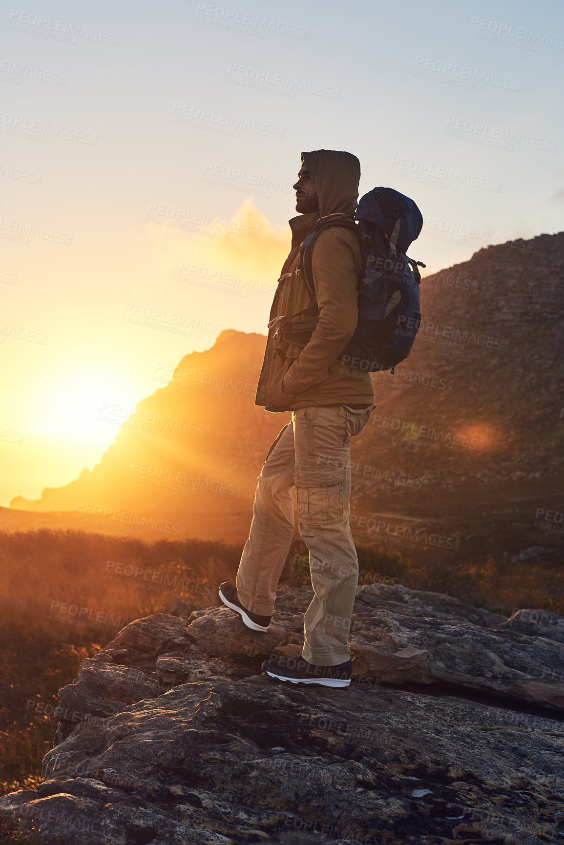 Buy stock photo Shot of a hiker on top of a mountain taking in the views of the morning sun