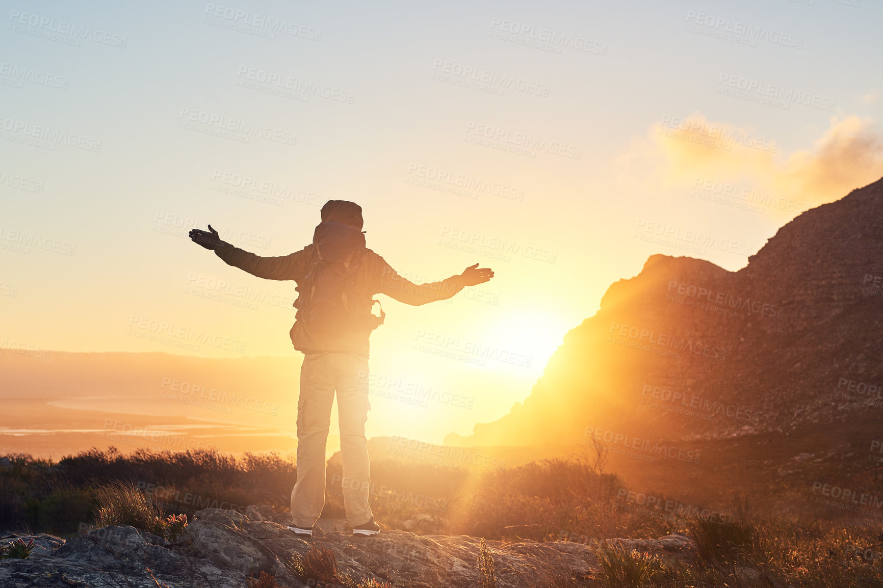 Buy stock photo Mountain, sunset and person with hiking achievement, freedom and trekking vacation with calm horizon. Sky, view and excited hiker with arms raised on cliff for outdoor adventure holiday in nature