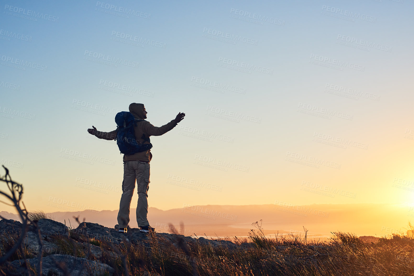 Buy stock photo Mountain, sunset and person with hiking freedom, achievement and trekking vacation with calm horizon. Sky, view and excited hiker with arms raised on cliff for outdoor adventure holiday in nature