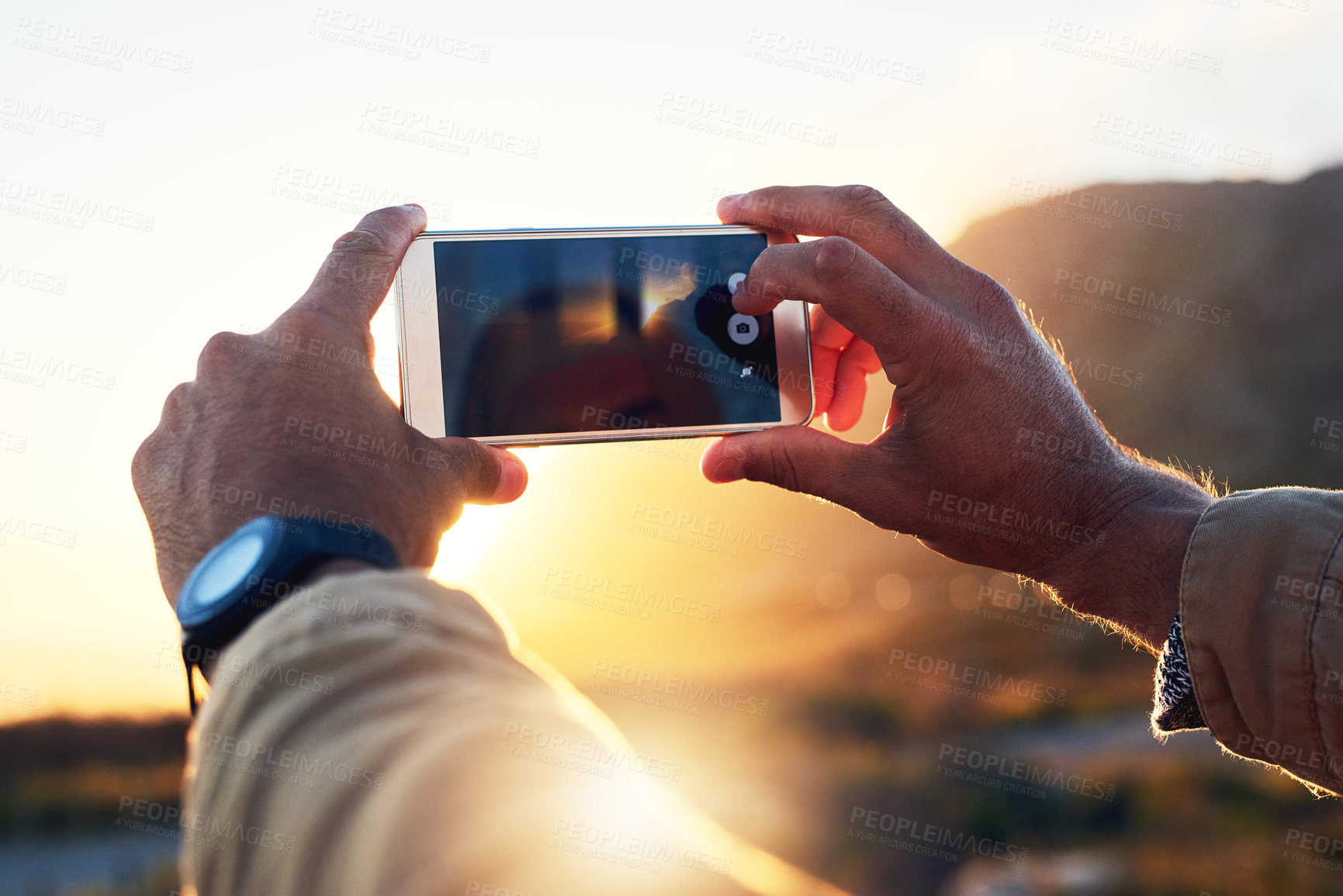 Buy stock photo Shot of a hiker on top of a mountain capturing a picture