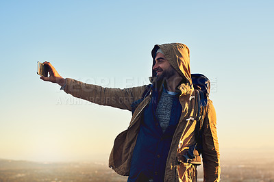 Buy stock photo Shot of a hiker on top of a mountain taking a selfie