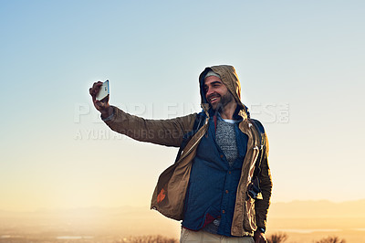 Buy stock photo Shot of a hiker on top of a mountain taking a photo of himself