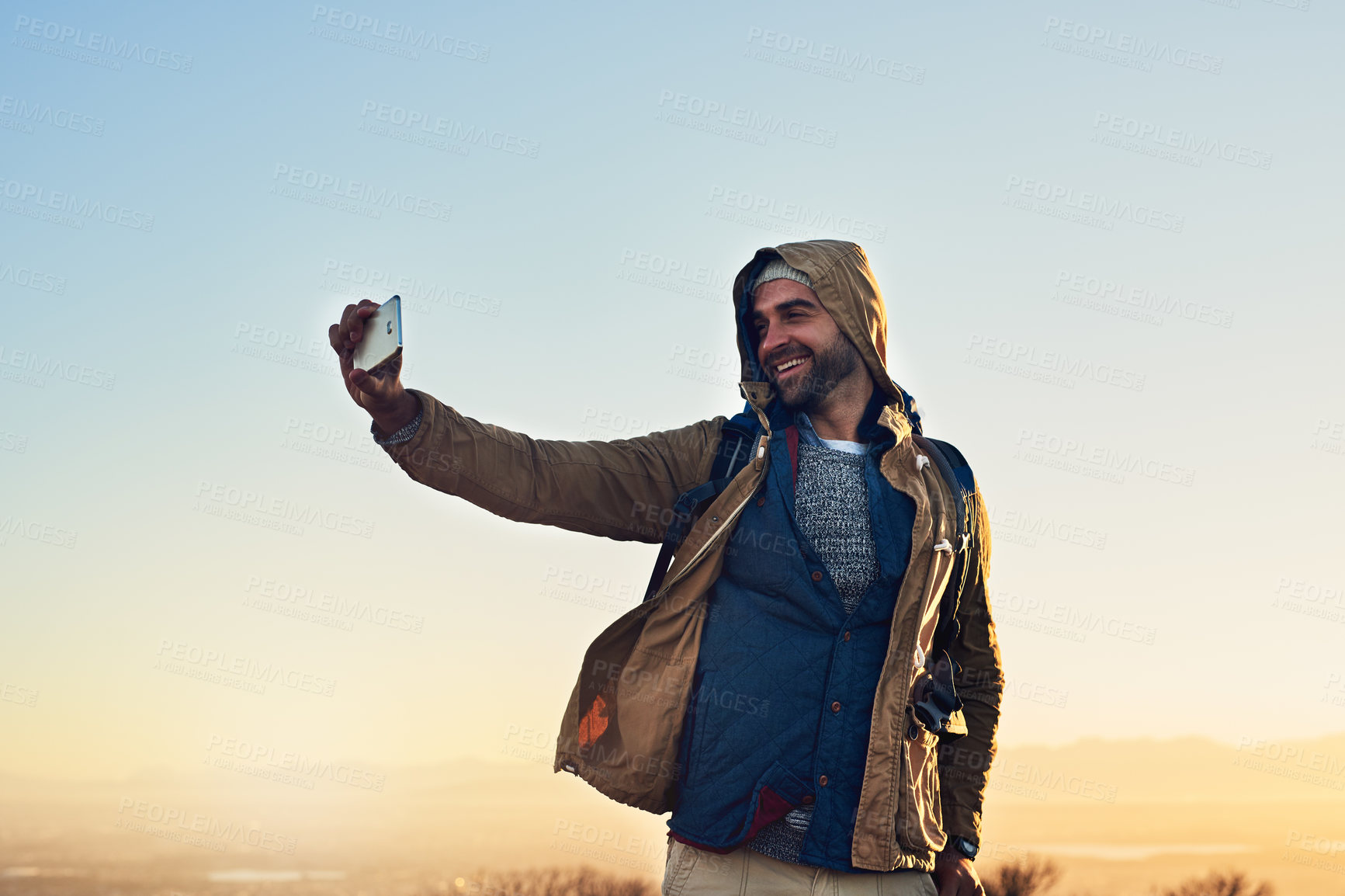 Buy stock photo Blue sky, smile and man with selfie in nature for adventure, online post or memory of hiking. Happy, person and sunrise with digital photography on mountain for social media, travel update or holiday