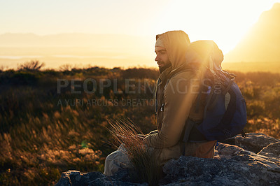 Buy stock photo Shot of a hiker siting on top of a mountain in deep thought