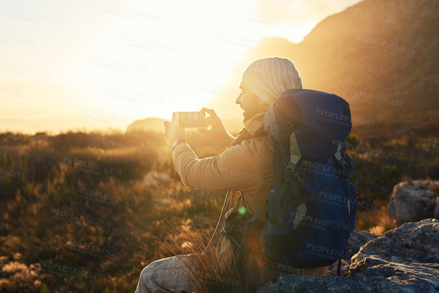Buy stock photo Shot of a hiker on top of a mountain capturing pictures of the view