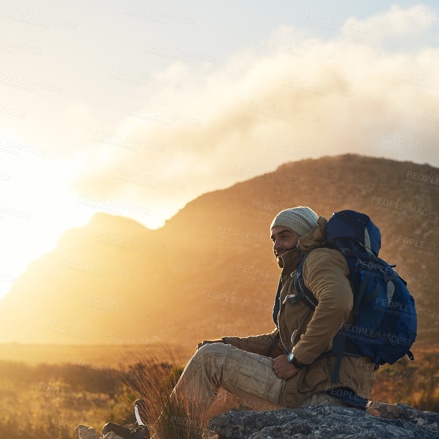 Buy stock photo Shot of a hiker sitting on top of a mountain smiling