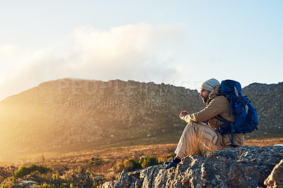 Buy stock photo Shot of a hiker sitting on top of a mountain thinking