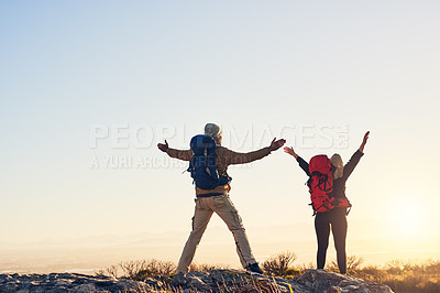 Buy stock photo Shot of two hikers on top of a mountain with their arms raised enjoying the views