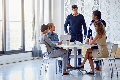 Buy stock photo Shot of a team of businesspeople working on a laptop together at a table in the office