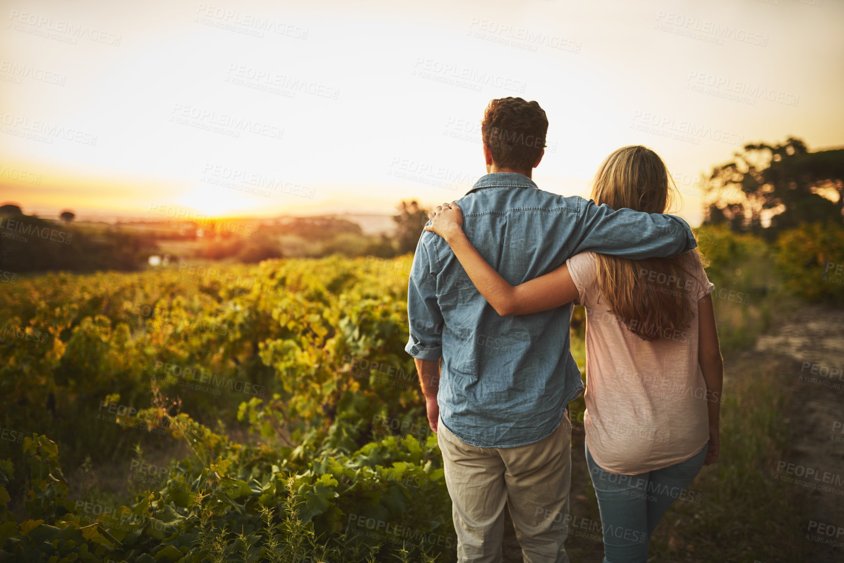 Buy stock photo Back, hug and couple in farm, outdoor and bonding in nature, love and date for anniversary in park. Morning, partner and person with embrace, sunrise and peace in countryside, field or relax in Texas