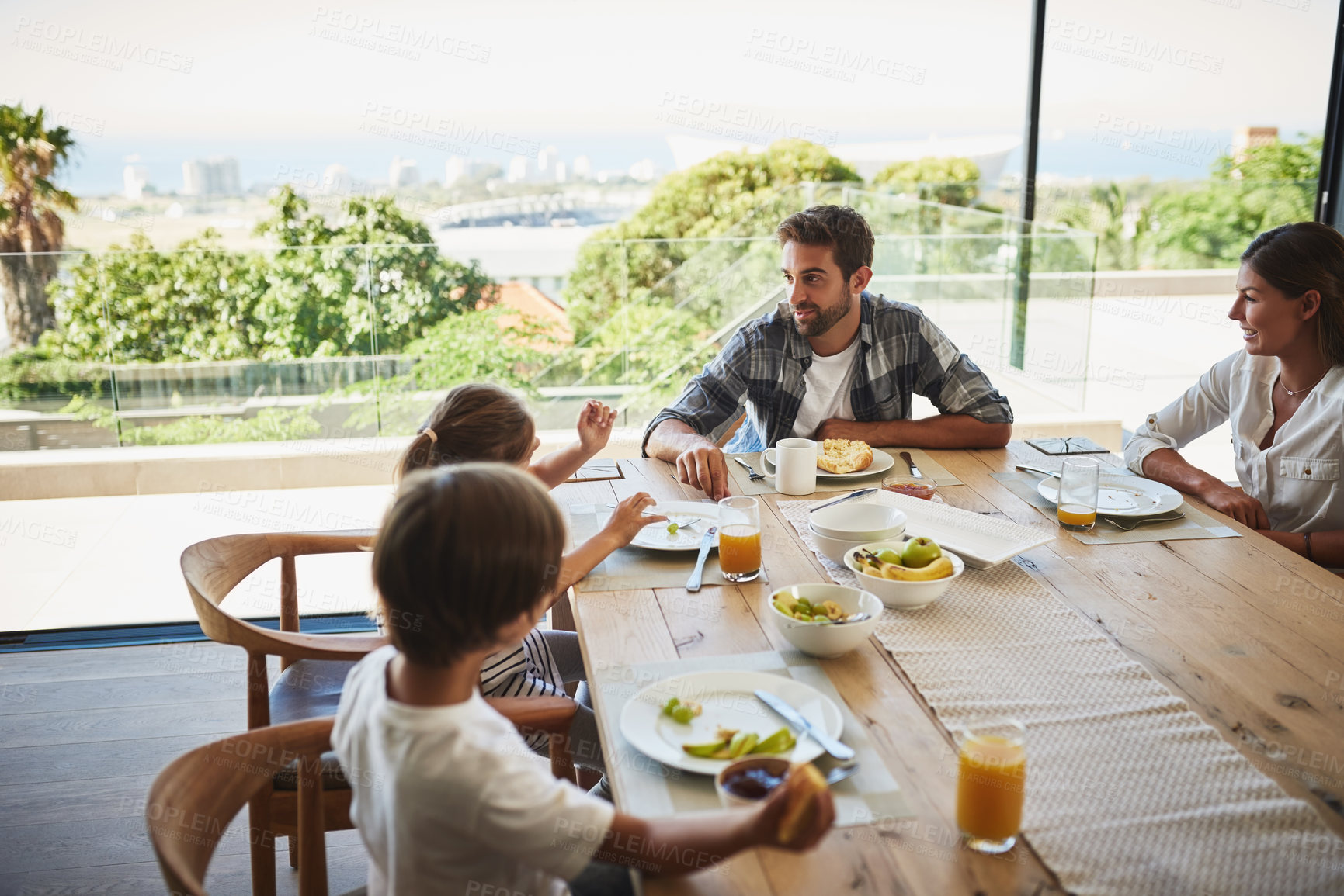 Buy stock photo Family, breakfast and food in house with cereal, juice and fruit for health or nutrition by table. Father, talk and kids together in home in morning for wellness, brunch and support with happiness 