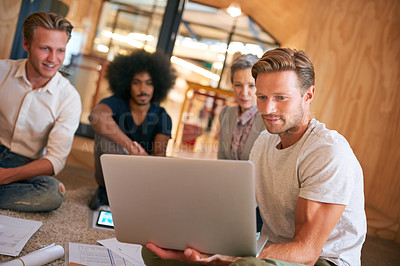 Buy stock photo Shot of a team of designers brainstorming on the floor in an office