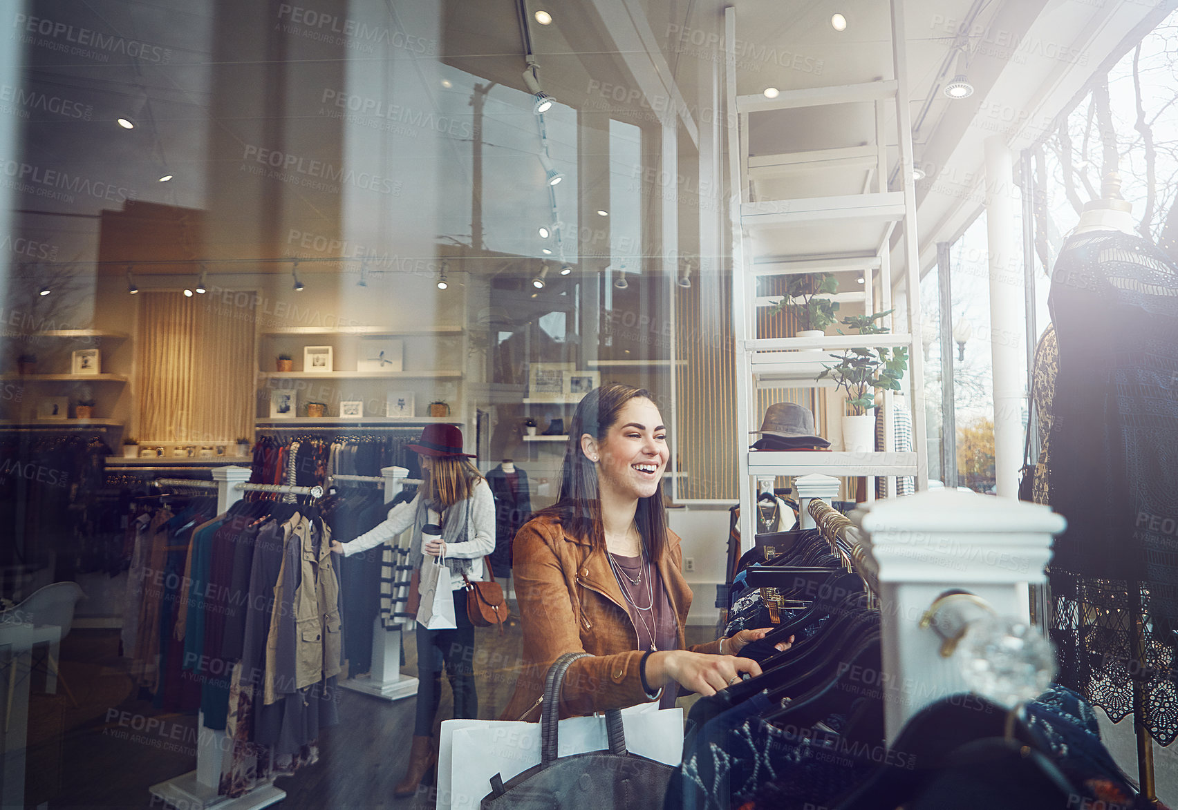 Buy stock photo Shot of a young woman shopping at a clothing store