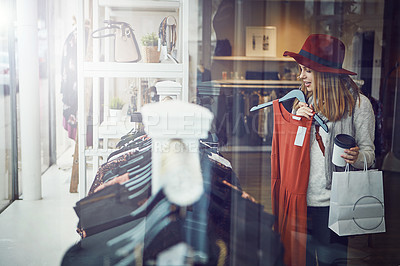 Buy stock photo Shot of a young woman shopping at a clothing store