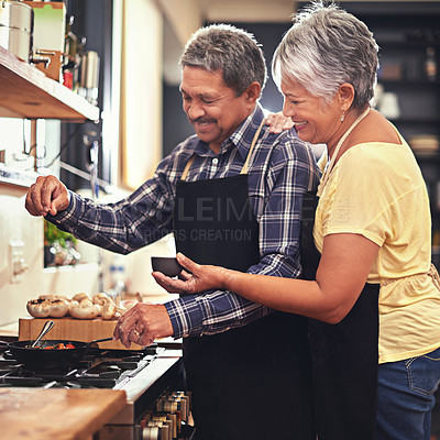 Buy stock photo Shot of a mature couple cooking together at home