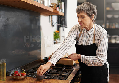 Buy stock photo Shot of a mature woman cooking at home