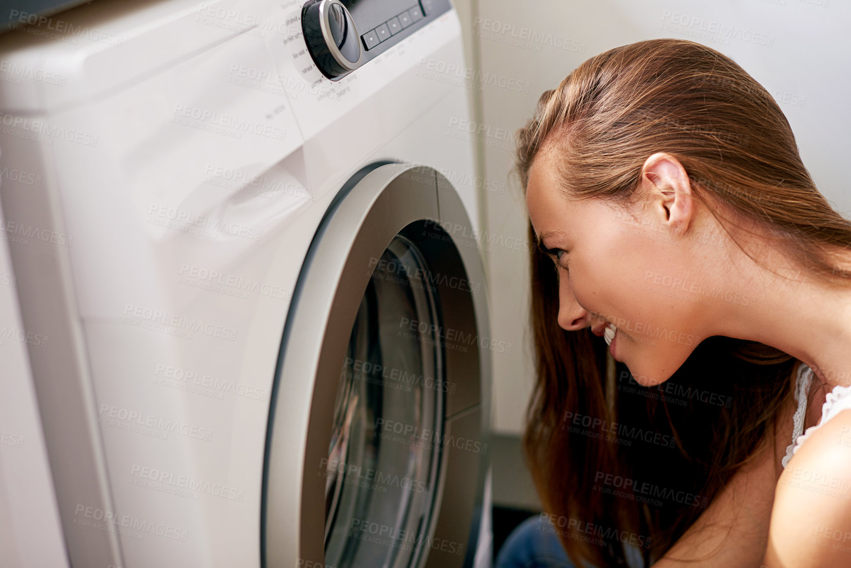 Buy stock photo Cropped shot of young woman doing laundry at home