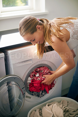 Buy stock photo Cropped shot of young woman doing laundry at home