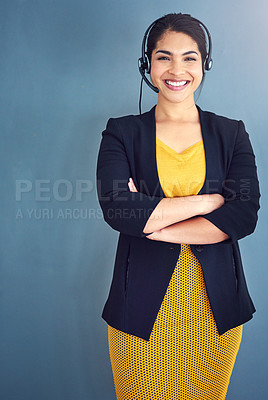 Buy stock photo Studio portrait of an attractive young businesswoman standing against a blue background